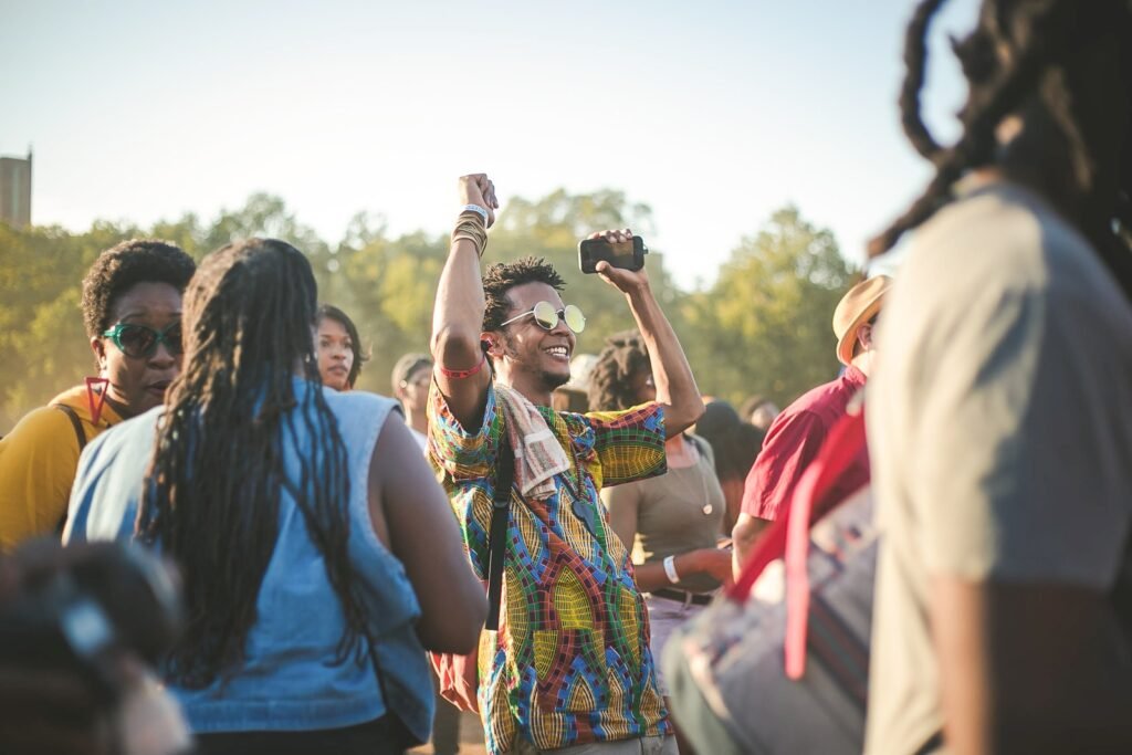 man wearing multicolored shirt dancing in the middle of crowd